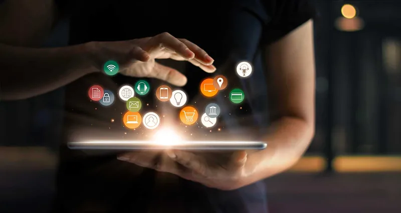 Mains au-dessus d'une tablette d'où s'élèvent des icônes d'applications et de services